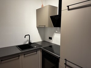 Eine moderne Küche mit Spüle, Herd und Schränken.