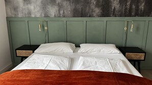 A bed with white linens, a green headboard, and two bedside tables with woven baskets. - Faraway Homes Studio Semmering #105 (Spital am Semmering)