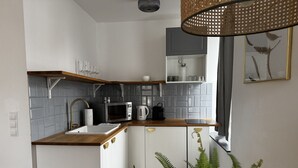 A compact kitchen with a wooden countertop, white cabinets, and a window. - Faraway Homes Studio Semmering #105 (Spital am Semmering)