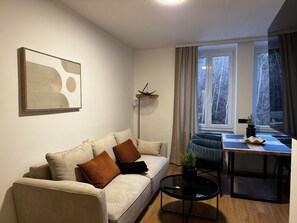 Ein modernes Wohnzimmer mit einer Couch, einem Esstisch und einer Stehlampe.