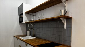 Een keuken met een houten aanrecht, een spoelbak en een magnetron.