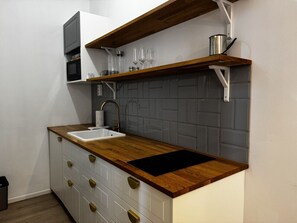 A kitchen with a wooden countertop, a sink, and a microwave.