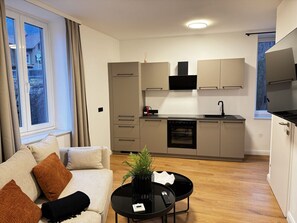 En modern lägenhet med vardagsrum, kök och matplats.