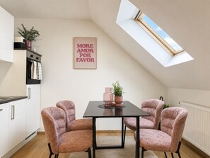 A dining area with a table and four chairs, a potted plant, and a framed sign on the wall. - FarawayHomes Studio Klagenfurt #1 (Klagenfurt am Wörthersee)