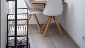 Um quarto pequeno e bem organizado, com uma escrivaninha, cadeira e uma escada.