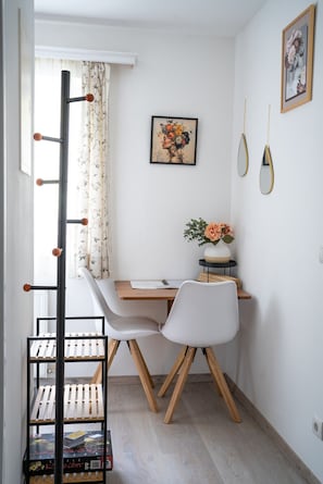 A small, neatly organized room with a desk, chair, and a ladder.