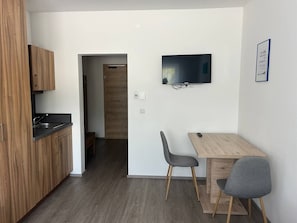 Eine moderne Küche mit Holdekor, einem eingebauten Spülbecken und einem Essbereich mit Tisch und zwei Stühlen.