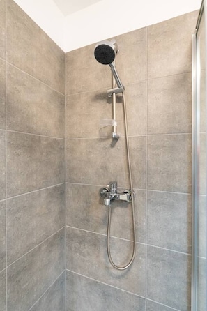 Eine Dusche mit Handbrause und Duschschlauch.