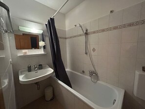 Ein Badezimmer mit einer Badewanne, einem Waschbecken und einer Dusche.