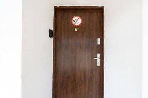 A wooden door with a no-smoking sign, a keyhole, and a door handle. - FarawayHomes Studio Vienna #1 (Vienna)