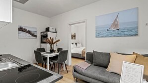 A modern living space with a kitchen, dining area, and a bedroom. - FarawayHomes Studio Mürzzuschlag #4 (Mürzzuschlag)