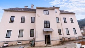 A two-story building with multiple windows, a door, and a small balcony. - FarawayHomes Studio Mürzzuschlag #4 (Mürzzuschlag)