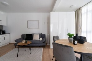 A modern living room with a sofa, coffee table, and dining table. - FarawayHomes Studio Fohnsdorf #A1 (Fohnsdorf)