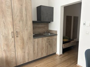 Eine Küche mit Holzschränken, einer schwarzen Arbeitsplatte und einem Spülbecken.
