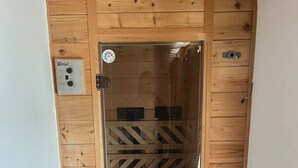 A wooden door with a glass panel, a thermostat, and a small electrical outlet on the wall. - FarawayHomes Studio Bruck #5 (Bruck an der Mur)