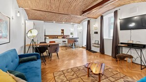 En moderne stue med en blå sofa, et træsofabord og et gulv med et fiskebensmønster.