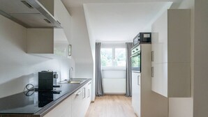 Una cocina moderna con horno empotrado, microondas y fregadero.