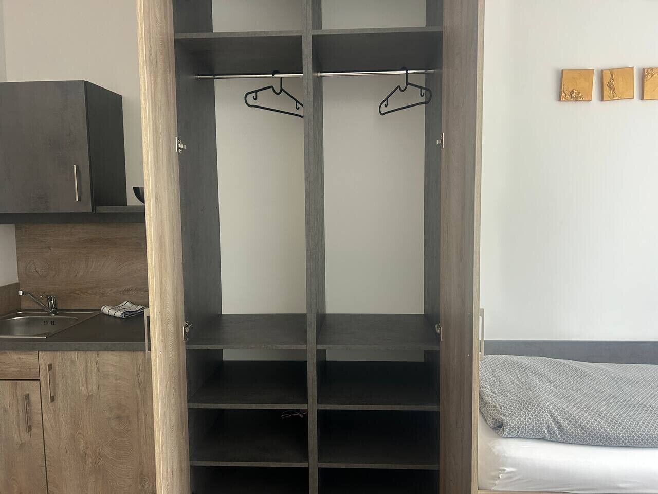Habitació amb armari, llit i pica.