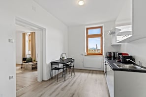 A modern kitchen with a dining area, a window with a view, and a small living space. - FarawayHomes Studio Saint Michael #10 (Liesingtal)