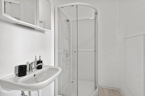 A bathroom with a white sink, a mirror, and a glass shower enclosure. - FarawayHomes Studio Saint Michael #10 (Liesingtal)