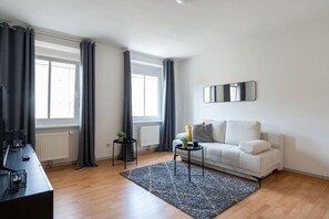 Una sala de estar moderna con sofá, mesa de centro, mesita auxiliar y radiador.