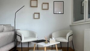 A modern living room with a white sofa, a coffee table, and a floor lamp. - FarawayHomes Studio Vienna #H1 (Vienna)