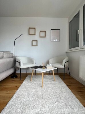 A modern living room with a white sofa, a coffee table, and a floor lamp. - FarawayHomes Studio Vienna #H1 (Vienna)