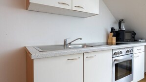 A kitchen with a stainless steel sink, a microwave, and a stove. - FarawayHomes Studio Graz #6 (Graz)
