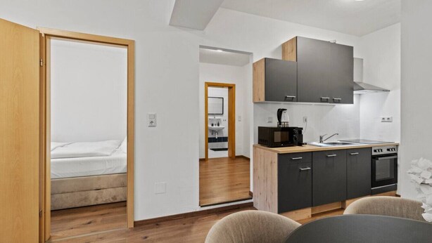 A compact living space with a kitchenette, a bed, and a dining area. - FarawayHomes Studio Fohnsdorf #4 (Fohnsdorf)