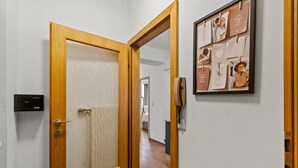 A wooden door with a towel hanging on the doorknob, a wall-mounted intercom, and a framed photo collage on the wall. - FarawayHomes Studio Fohnsdorf #4 (Fohnsdorf)