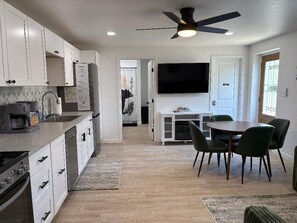 A modern kitchen with white cabinets, a built-in dishwasher, a stove, and a ceiling fan. - Mountain Views + Walkable + Laundry + King Bed+ 6 miles From Sequoia (Three Rivers)
