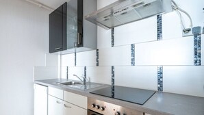 Une cuisine moderne équipée d’un four encastré, d’un évier et d’une cuisinière.