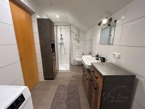 Ein modernes Badezimmer mit Dusche, Toilette und Waschbecken.