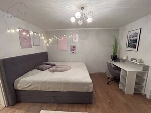Ein Schlafzimmer mit Bett, Schreibtisch, Stuhl und Wanddekorationen.