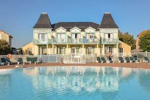 A hotel with a swimming pool, multiple balconies, and a traditional architectural style. - Coast Home With Play Area (Talmont-Saint-Hilaire)