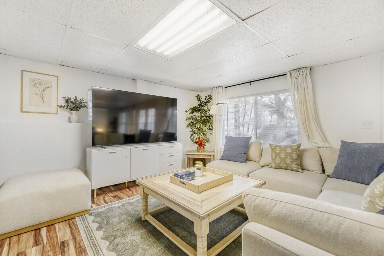 A living room with a sofa, a coffee table, a TV, and a cabinet.