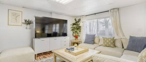 A living room with a sofa, a coffee table, a TV, and a cabinet.