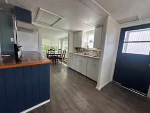 A kitchen with a central island, white cabinets, a sink, and a window.