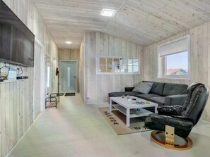Ein modernes Interieur mit einer Couch, einem Couchtisch und einem Sessel.