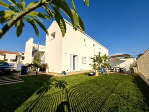 A white building with a flat roof, a small front porch, and a well-maintained lawn. - Apartment in Villa with garden and private terrace (Kaukana)