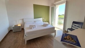 Ein Schlafzimmer mit einem Bett, Nachttischen, einem Sessel und einem Buch auf einem Tisch.