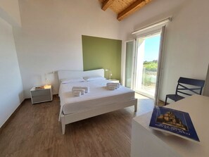 A bedroom with a bed, bedside tables, a chair, and a book on a table. - Apartment in Villa with garden and private terrace (Kaukana)