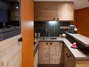 A modern kitchen with wooden cabinets, a stainless steel sink, and a coffee machine. - Retreat With Spa Access (Araches-la-Frasse)