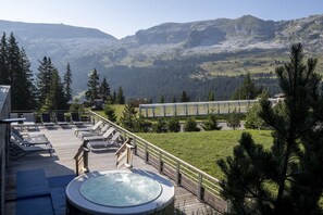 A hot tub on a deck with lounge chairs, overlooking a mountainous landscape. - Retreat With Spa Access (Araches-la-Frasse)