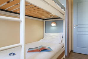A bunk bed with a book on it, a small toy car, and a door to the right. - Cozy Stay by the Shops (Fort-Mahon-Plage)