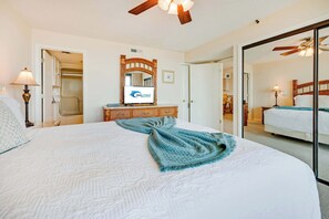 Ein Hotelzimmer mit einem großen Bett, einem Spiegel, einem Fernseher und einer Holzkommode.