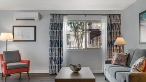 Un saló amb un sofà, una butaca i una taula amb un bol decoratiu.
