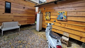 A wooden cabin with a bench, a scooter, and two paintings on the wall. - Casa G 36 M8  (Mexico City)