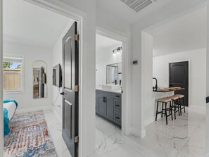 Eine moderne Küche mit Spüle, Schränken und einer Bar mit Sitzgelegenheiten.