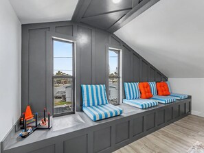 Eine schräge Decke mit integriertem Sitzbereich, große Fenster und ein Blick ins Freie.